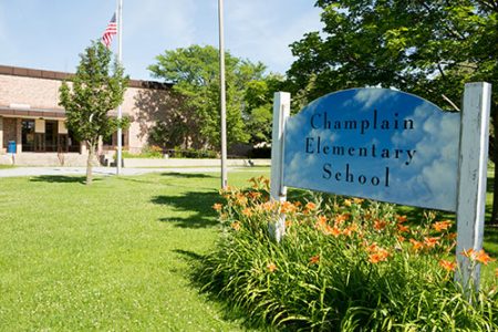 Champlain School image of front of building and green.